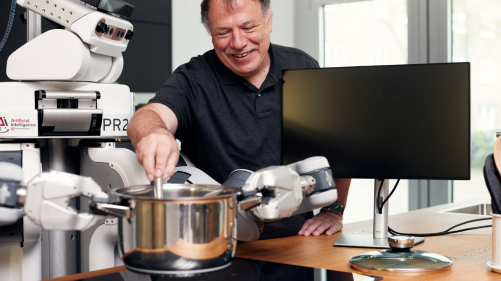 CoAI co-speaker Michael Beetz cooks with a PR2 robot in a kitchen lab